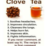 Glass mug of clove tea beside a small pile of whole dried cloves.